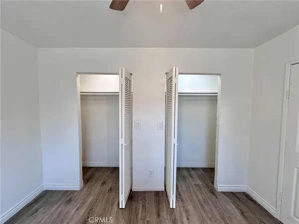 a view of walk in closet with wooden floor