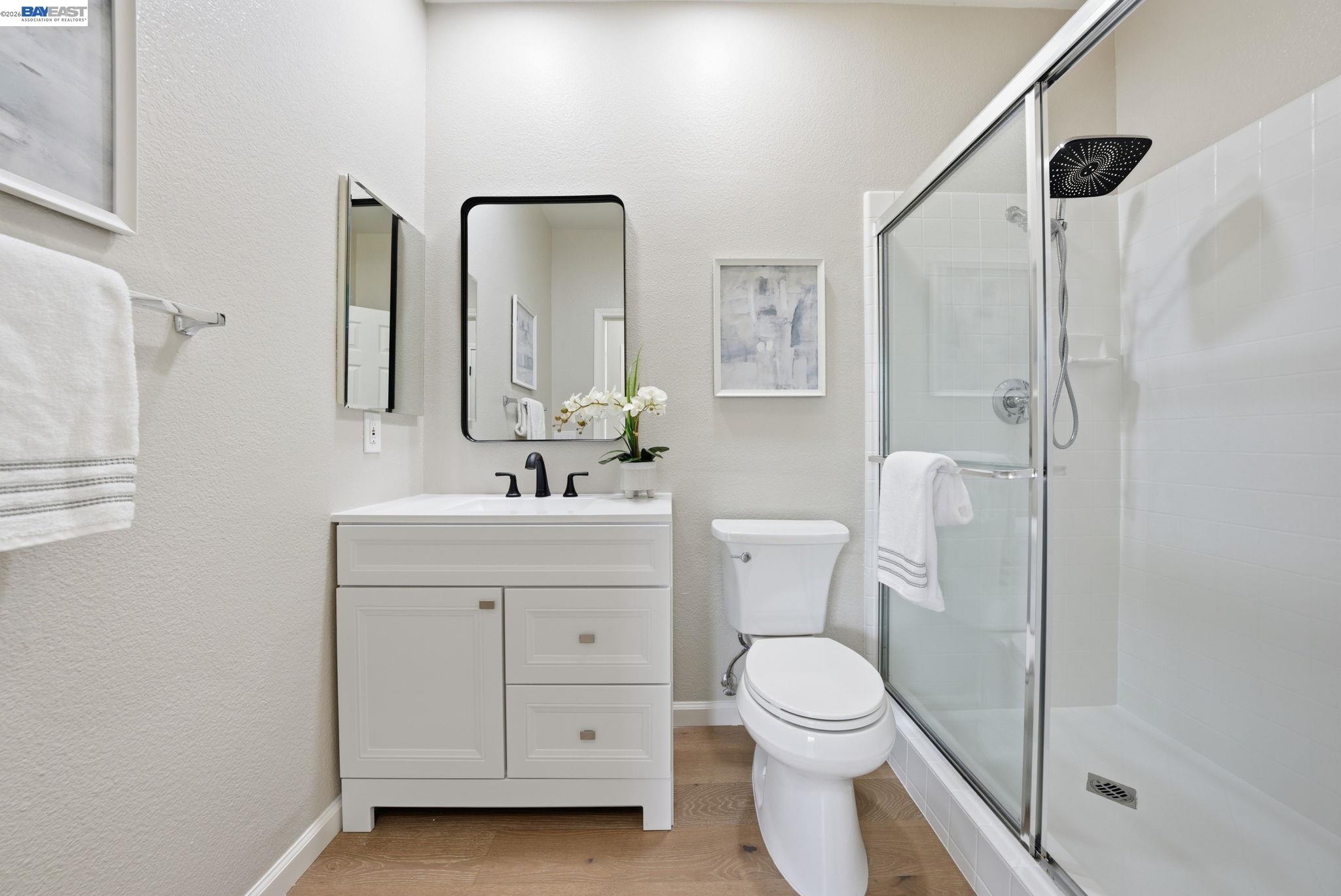 Westside San Ramon, CA 94583 - Photo 19 of 43 a bathroom with a toilet a sink a mirror and a shower