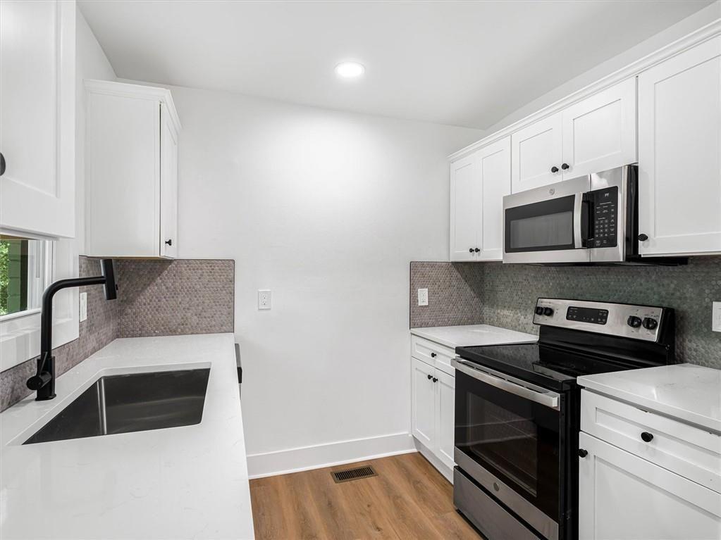 454 Oak Drive Southeast Atlanta, GA 30354 - Photo 11 of 29 a kitchen with stainless steel appliances a stove microwave and sink