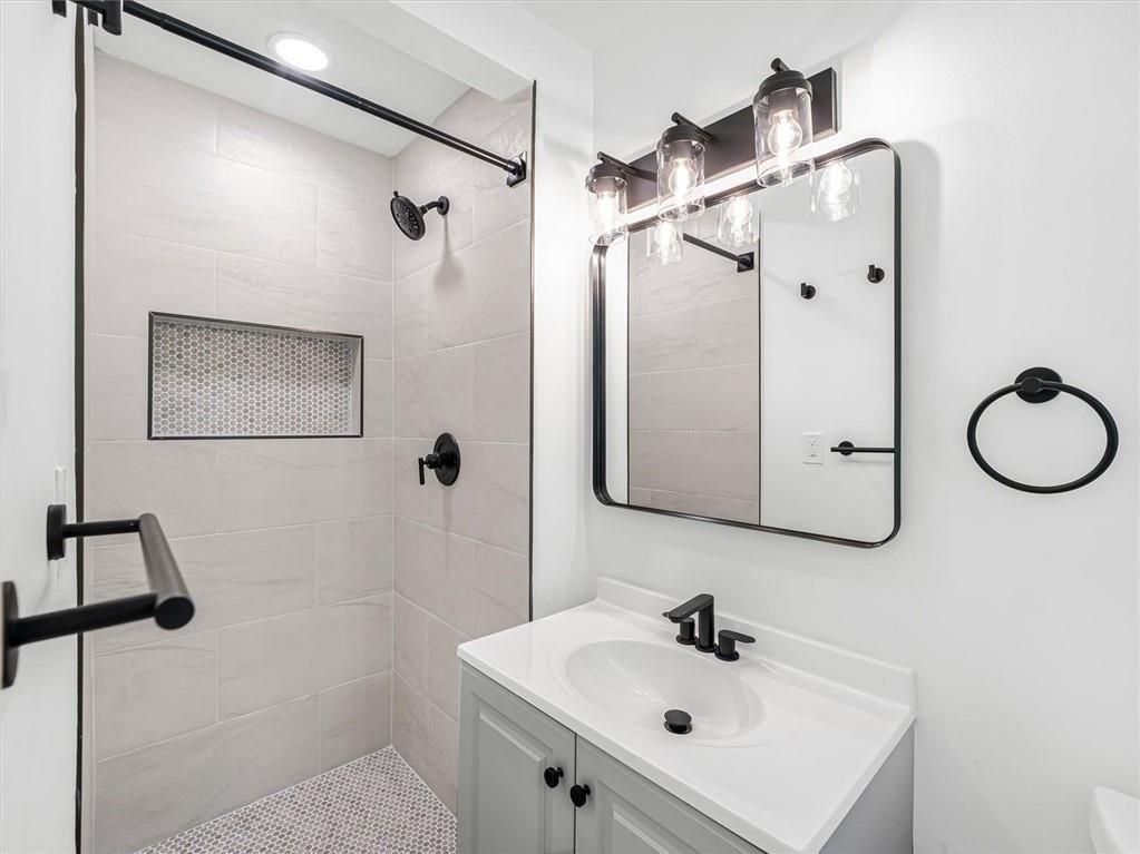 454 Oak Drive Southeast Atlanta, GA 30354 - Photo 24 of 29 a bathroom with a sink a mirror a vanity and shower