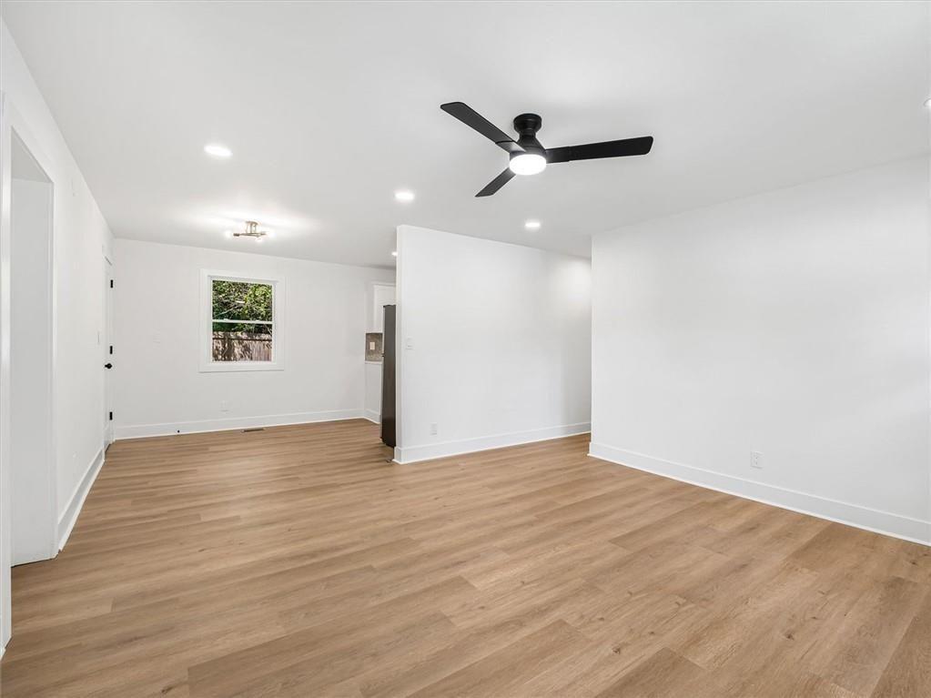 454 Oak Drive Southeast Atlanta, GA 30354 - Photo 5 of 29 a view of an empty room with wooden floor and a ceiling fan