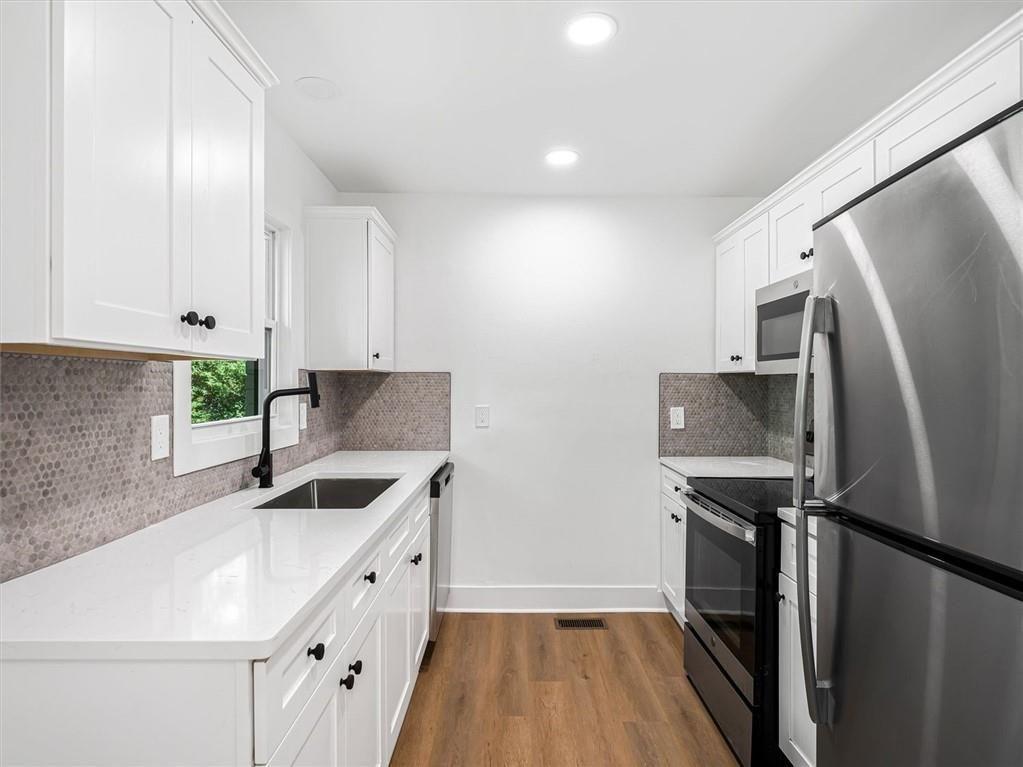 454 Oak Drive Southeast Atlanta, GA 30354 - Photo 10 of 29 a kitchen with a sink a refrigerator and cabinets