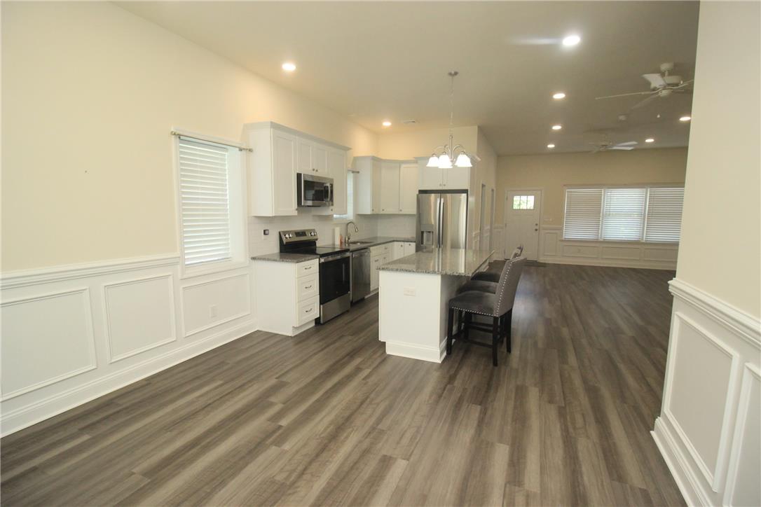 3083 Penn Allen Road, Unit B Nazareth, PA 18064 - Photo 20 of 21 An open-concept living space integrates a modern kitchen and dining area, featuring sleek wood-look flooring and wainscoting.