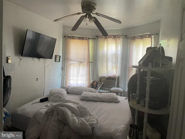 a bedroom with a bed window and flat screen tv