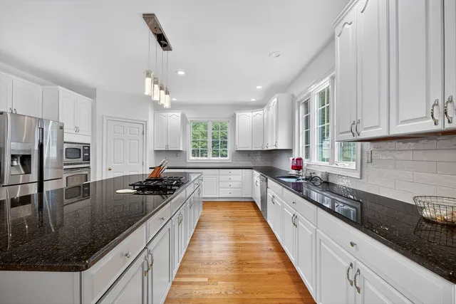 a kitchen with granite countertop a sink a counter space appliances and cabinets