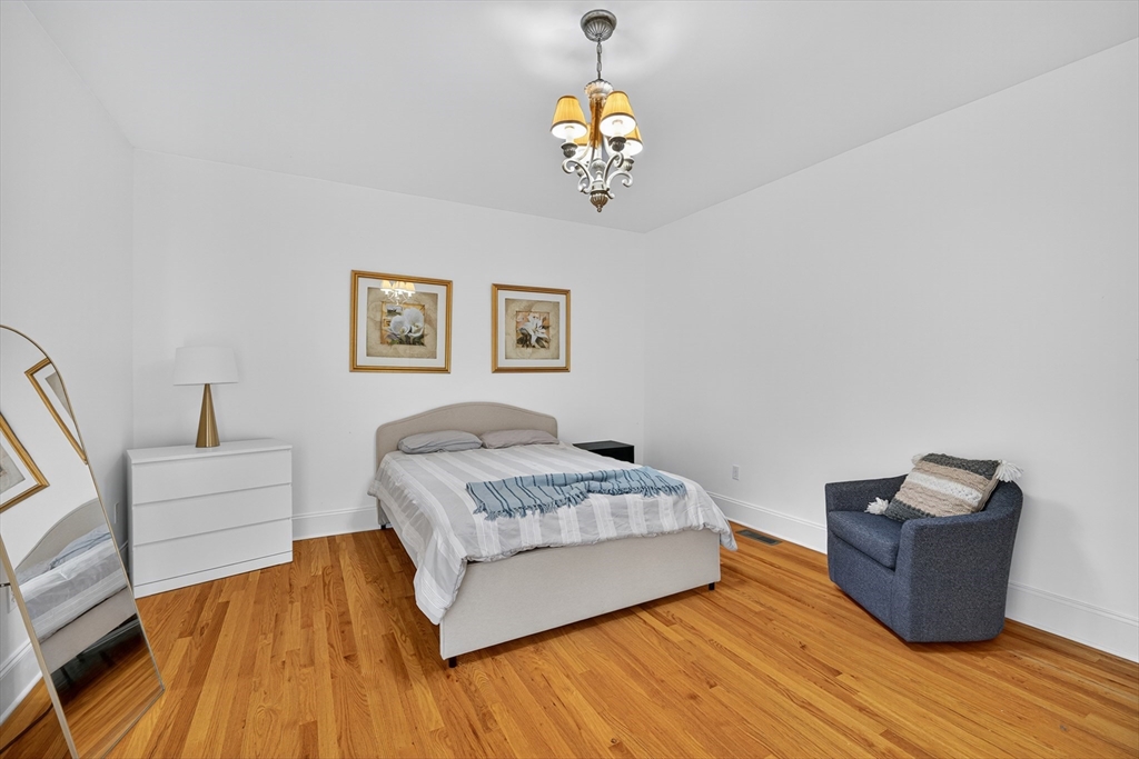 4 Summit Way, Unit 1 Hopkinton, MA 01748 - Photo 19 of 27 a spacious bedroom with a bed and a chandelier