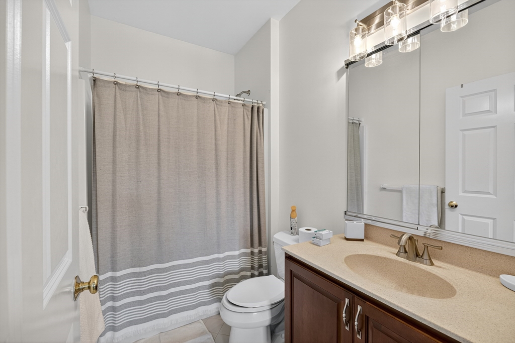 4 Summit Way, Unit 1 Hopkinton, MA 01748 - Photo 23 of 27 a bathroom with a sink a toilet and shower