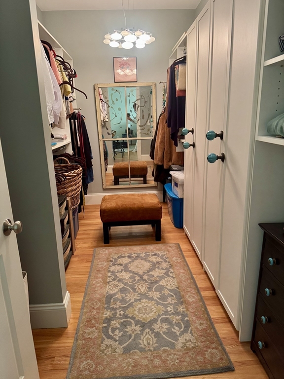 57 Hathaway Pond Circle, Unit 57 Rochester, MA 02770 - Photo 23 of 40 a bedroom with furniture and a chandelier