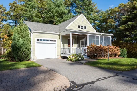 a front view of a house with a garden and trees