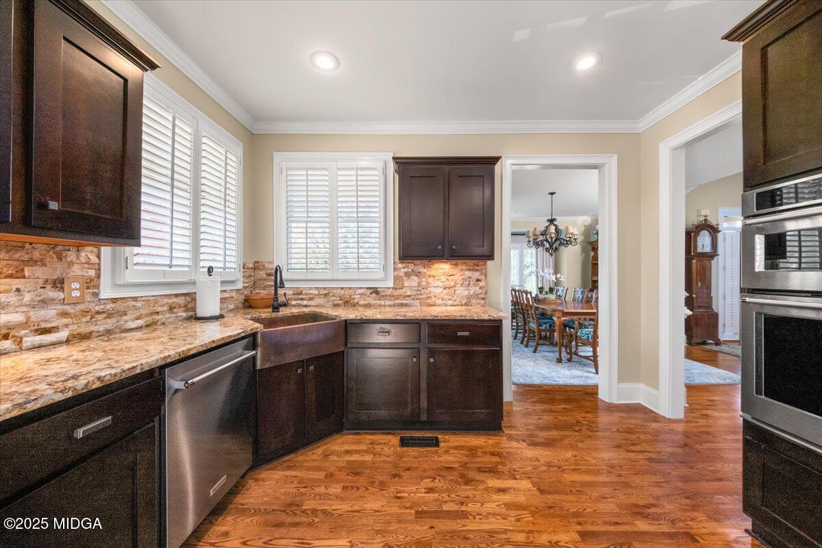 1060 East Magnolia Loop Madison, GA 30650 - Photo 5 of 41 a kitchen with stainless steel appliances granite countertop a sink stove and oven