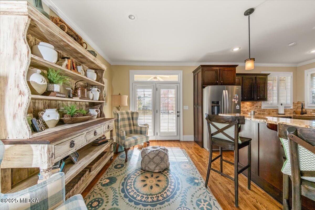 1060 East Magnolia Loop Madison, GA 30650 - Photo 6 of 41 a room with stainless steel appliances lots of wooden furniture and large windows
