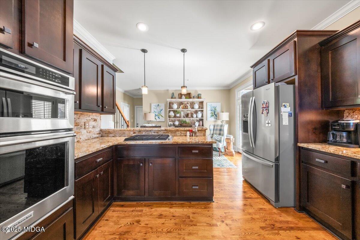 1060 East Magnolia Loop Madison, GA 30650 - Photo 8 of 41 a kitchen with stainless steel appliances granite countertop a refrigerator a stove and a sink