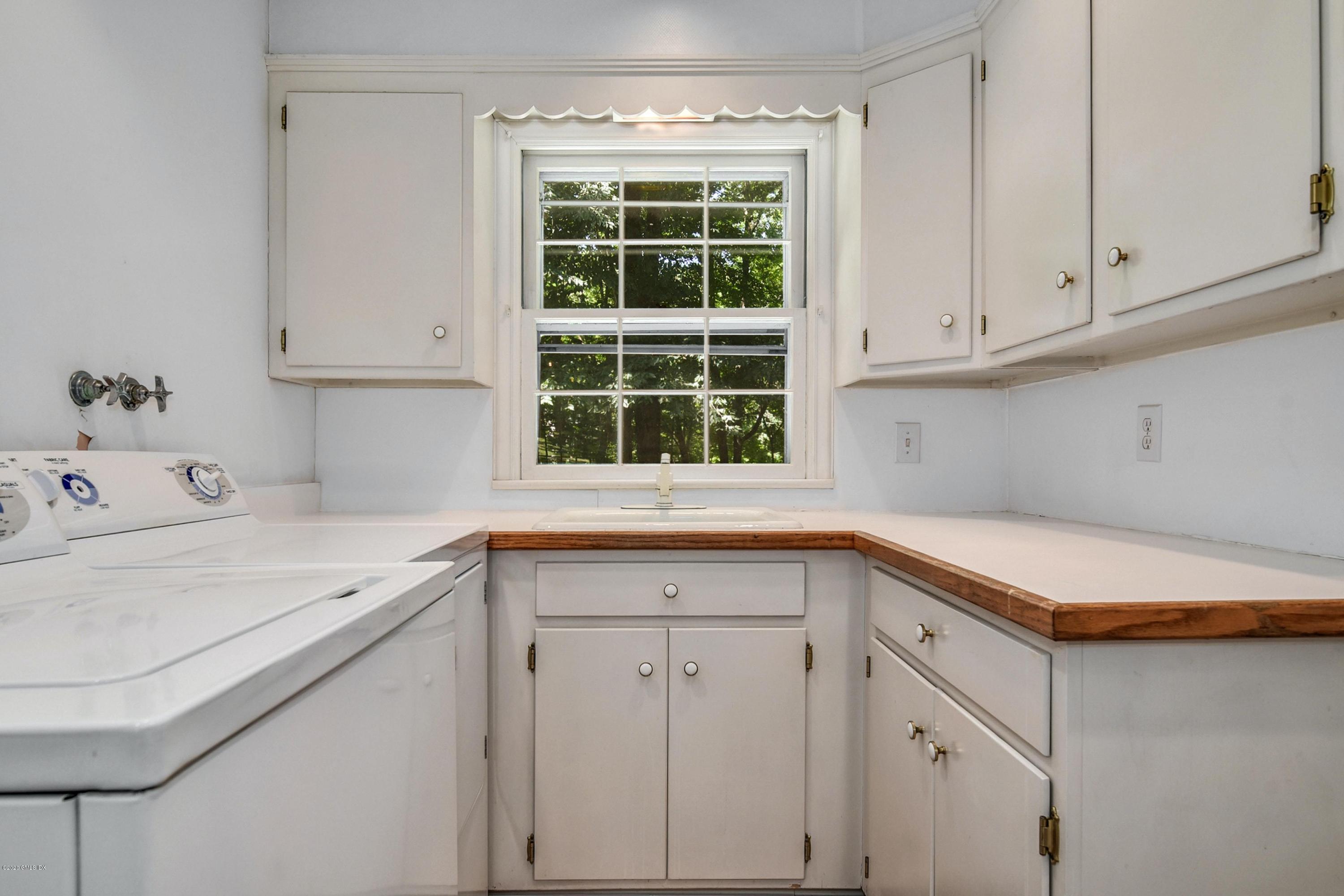 230 Stanwich Road Greenwich, CT 06830 - Photo 14 of 28 a kitchen with a sink dishwasher and white cabinets with wooden floor
