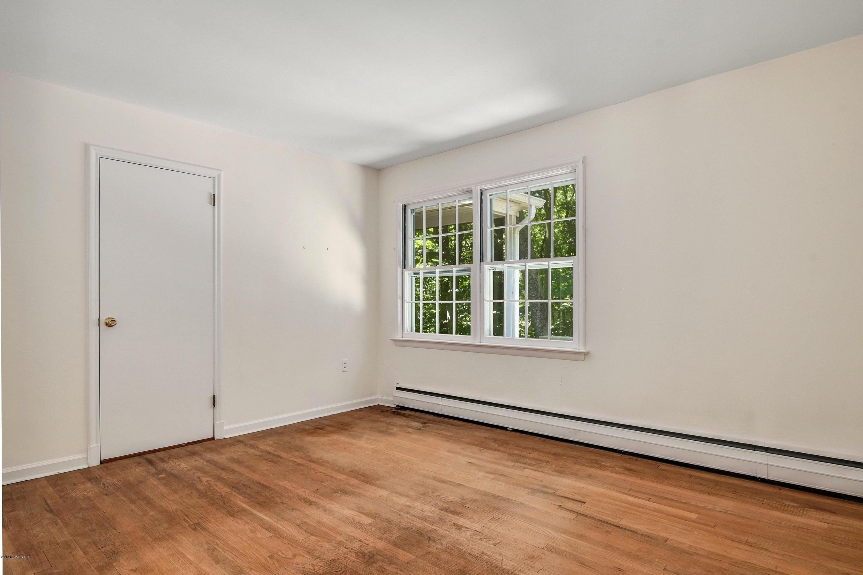 230 Stanwich Road Greenwich, CT 06830 - Photo 20 of 28 an empty room with wooden floor and windows