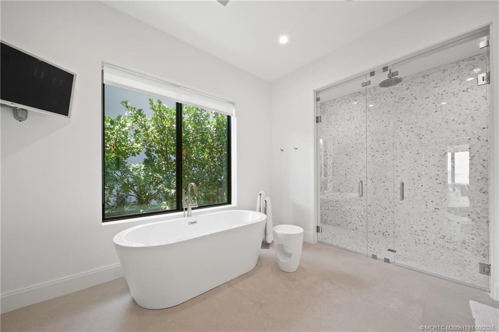 2834 Southwest Rivers End Way Palm City, FL 34990 - Photo 31 of 62 a bathroom with a bathtub and a shower