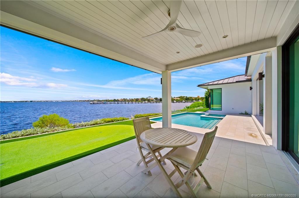 2834 Southwest Rivers End Way Palm City, FL 34990 - Photo 50 of 62 a view of a patio with a table and chairs under an umbrella