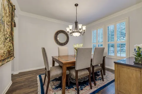 a view of a dining room with furniture a chandelier and wooden floor