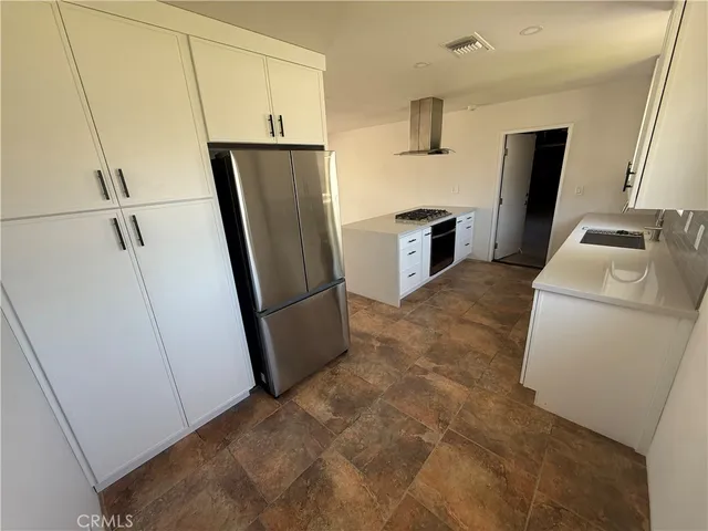 a kitchen with refrigerator a microwave and sink