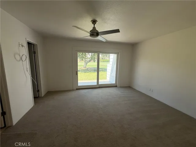 a view of a livingroom with a ceiling fan and window