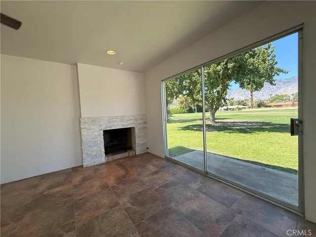 a view of an empty room with a fireplace and a large window