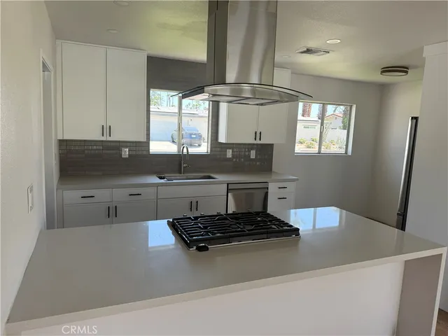 a kitchen with stainless steel appliances a sink stove and cabinets