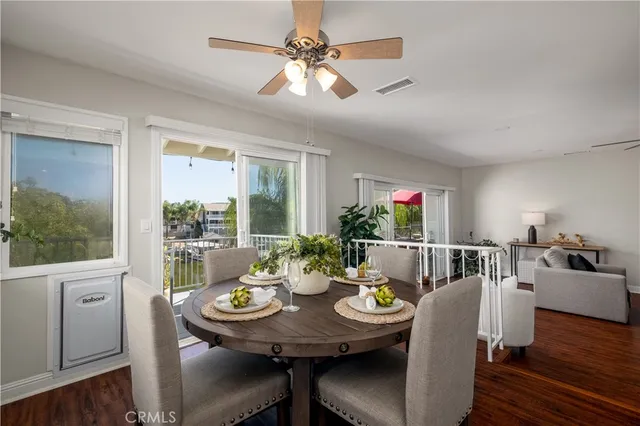 a living room with furniture a wooden floor and a kitchen view