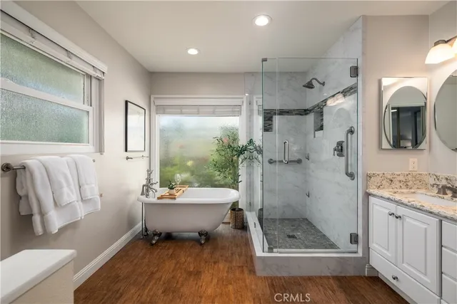 a bathroom with a granite countertop sink a toilet a mirror and shower