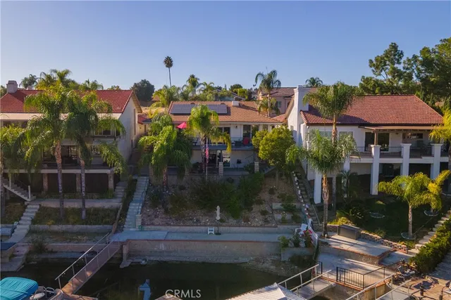 an aerial view of a house with a yard and lake view