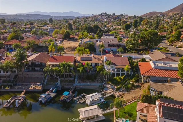 an aerial view of ocean and residential houses with outdoor space