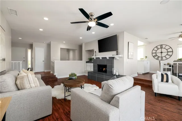 a living room with furniture a table and wooden floor