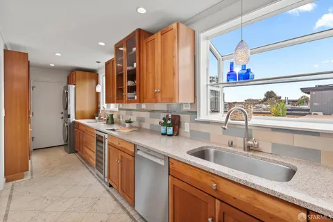 a kitchen with stainless steel appliances a sink stove and cabinets