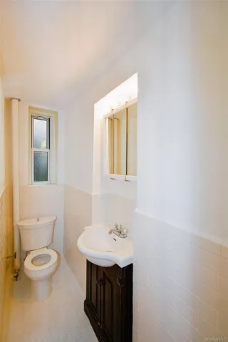 a bathroom with a sink a toilet and mirror