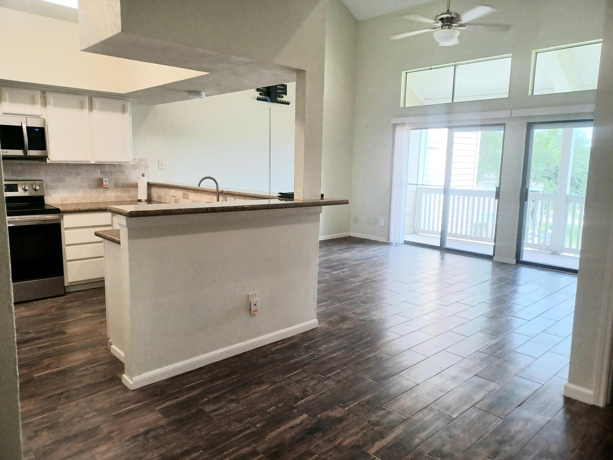 128 April Point Drive South Conroe, TX 77356 - Photo 6 of 26 a kitchen with stainless steel appliances granite countertop a sink a stove and a wooden floors