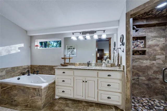 a bathroom with a bathtub a sink and a large mirror