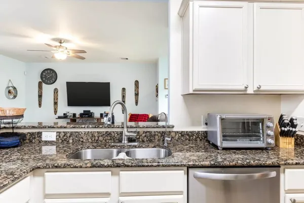 a kitchen with granite countertop a sink and a stove top oven with granite countertops