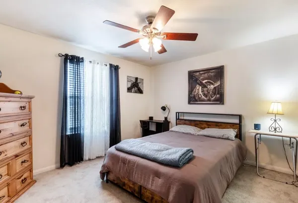 a bedroom with a large bed and a chandelier