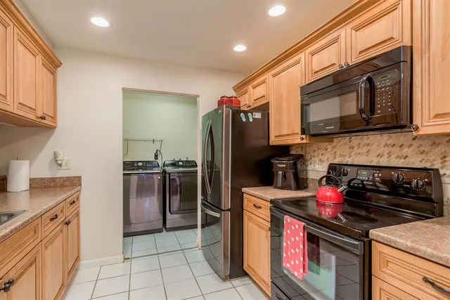 a kitchen with stainless steel appliances granite countertop a stove refrigerator and microwave