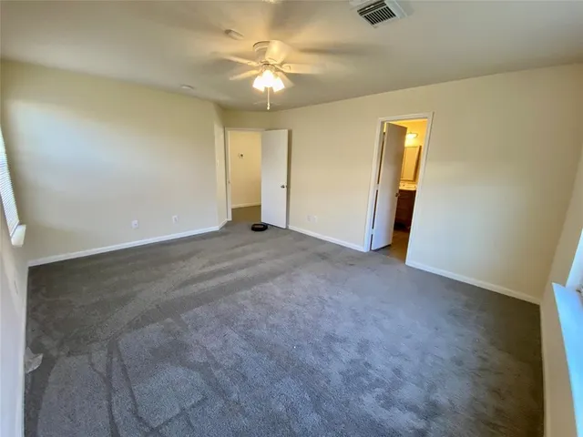 an empty room with a ceiling fan and closet