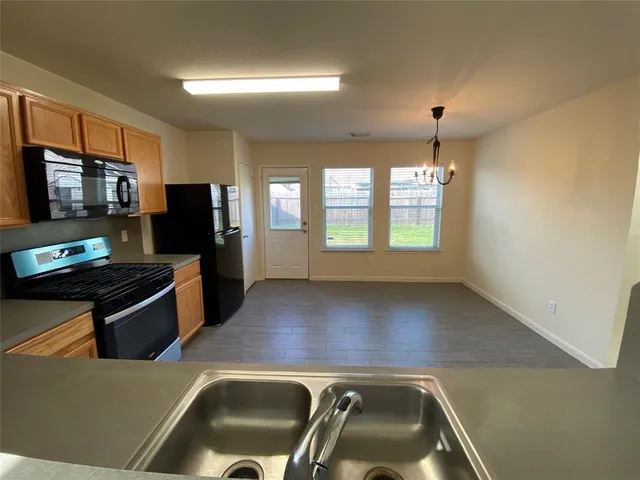 a view of a kitchen with a sink stove top oven and refrigerator