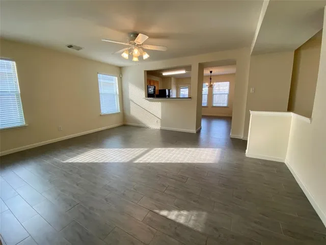 a view of a big room with wooden floor and a kitchen