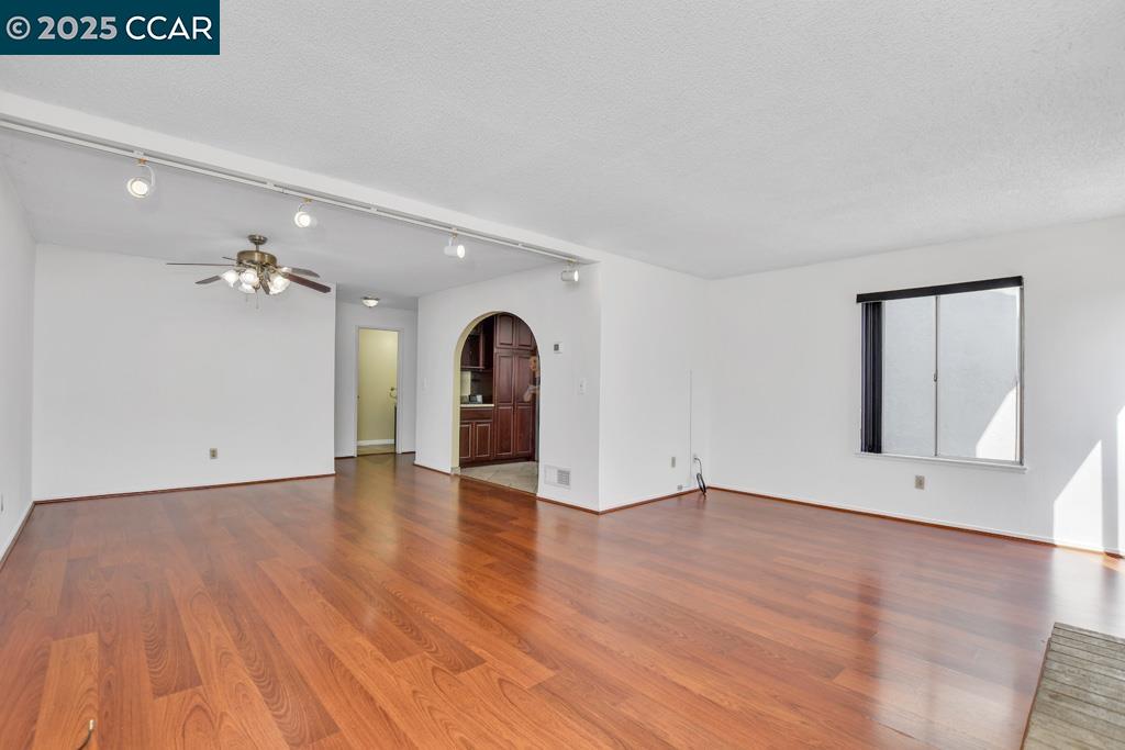 65 Edgewater Place Pittsburg, CA 94565 - Photo 11 of 31 a view of an empty room with wooden floor and a ceiling fan