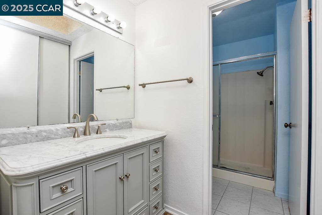 65 Edgewater Place Pittsburg, CA 94565 - Photo 27 of 31 a bathroom with a granite countertop sink and a mirror