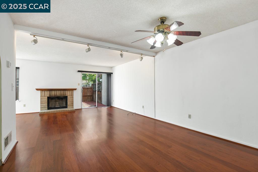 65 Edgewater Place Pittsburg, CA 94565 - Photo 7 of 31 a view of an empty room with wooden floor and a fireplace