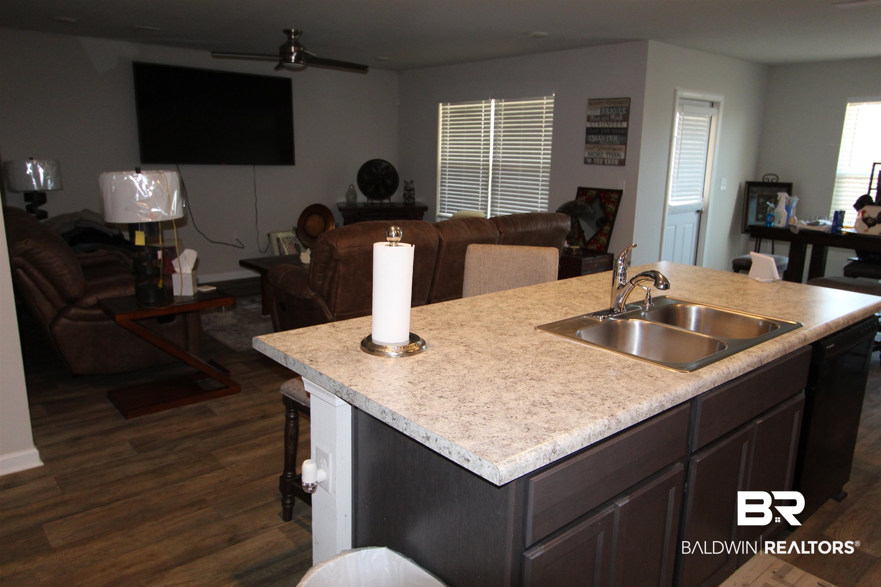 1502 Majesty Loop Foley, AL 36535 - Photo 8 of 26 Kitchen with dark brown cabinetry, sink, dark wood-type flooring, and an island with sink
