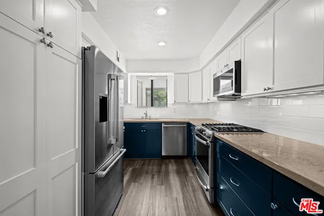 a kitchen with stainless steel appliances granite countertop a stove a sink and a refrigerator