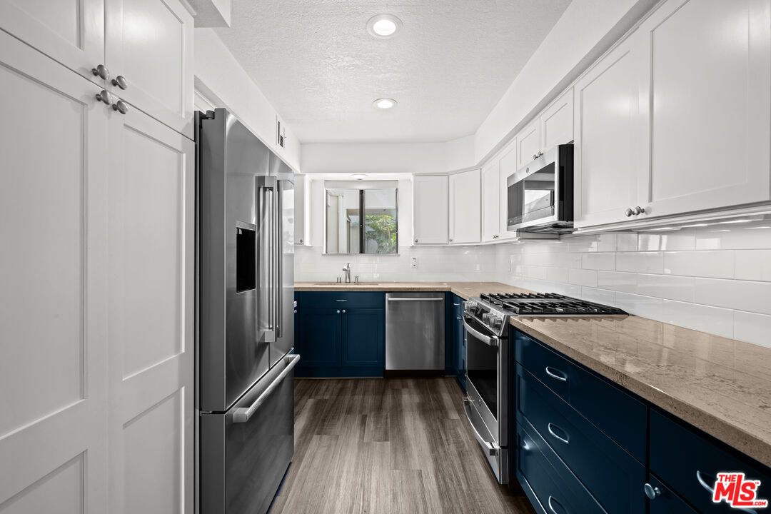 1312 South Saltair Avenue, Unit 215 Los Angeles, CA 90025 - Photo 12 of 31 a kitchen with stainless steel appliances granite countertop a stove a sink and a refrigerator