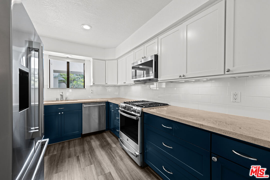 1312 South Saltair Avenue, Unit 215 Los Angeles, CA 90025 - Photo 13 of 31 a kitchen with stainless steel appliances granite countertop a stove a sink and a refrigerator