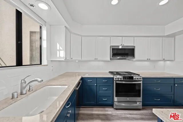 a kitchen with stainless steel appliances a stove a sink and a microwave