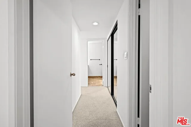 a view of a hallway with wooden shelves