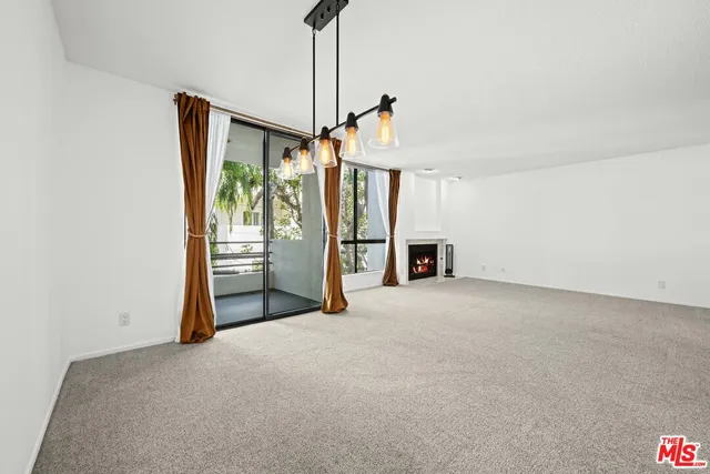a view of a room with a flat screen tv and refrigerator